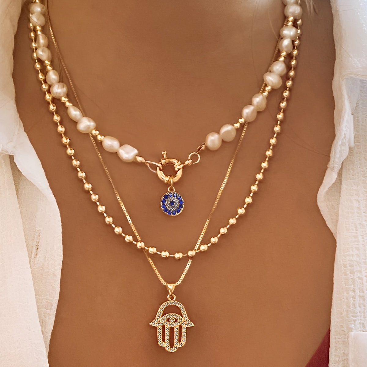 Nadia – Collier avec plusieurs rangées de perles et main de Hamsa