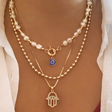 Nadia – Collier avec plusieurs rangées de perles et main de Hamsa