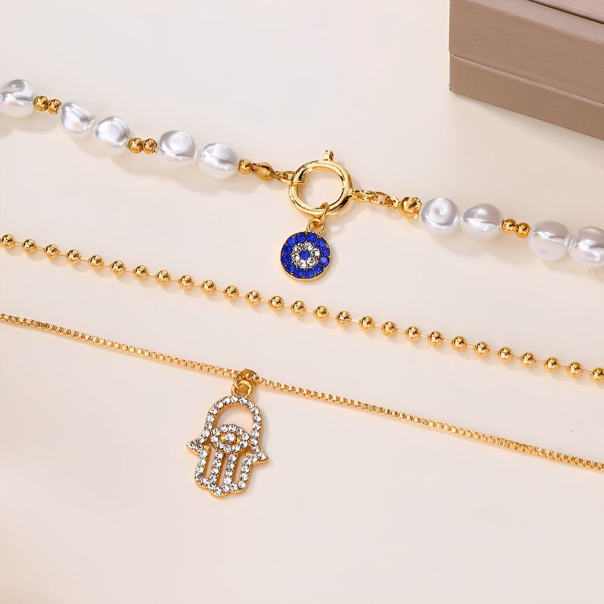 Nadia – Collier avec plusieurs rangées de perles et main de Hamsa